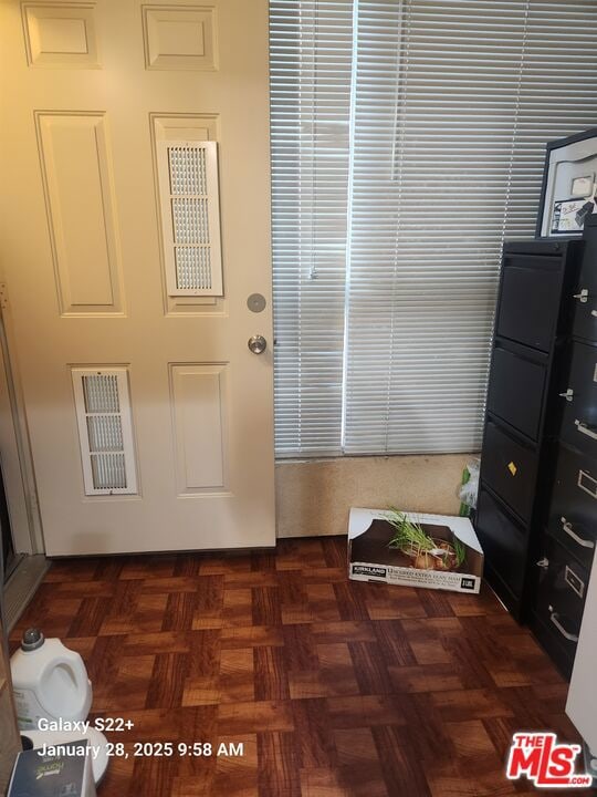 doorway with dark parquet flooring