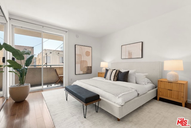 bedroom with wood-type flooring and access to outside