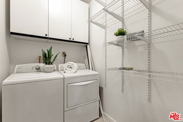 washroom with cabinets and washer and dryer