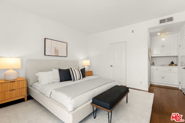 bedroom with dark hardwood / wood-style flooring