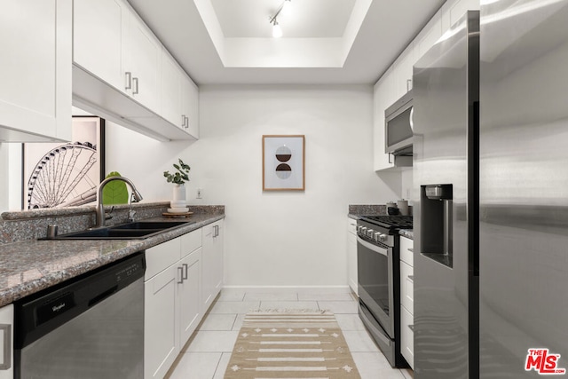 kitchen with dark stone countertops, sink, stainless steel appliances, and white cabinets