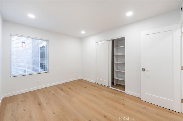 unfurnished bedroom featuring a closet and light hardwood / wood-style flooring