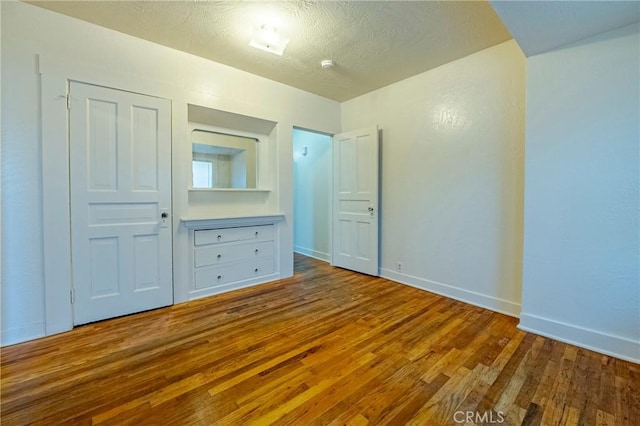 unfurnished bedroom with wood-type flooring and a textured ceiling