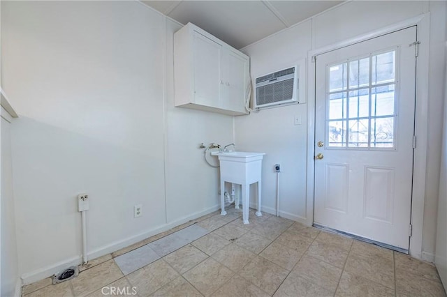 washroom with cabinets and an AC wall unit