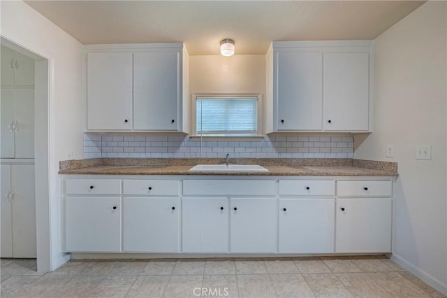 kitchen with white cabinetry, sink, and decorative backsplash