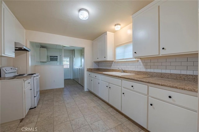 kitchen featuring sink, white electric range oven, white cabinets, and backsplash