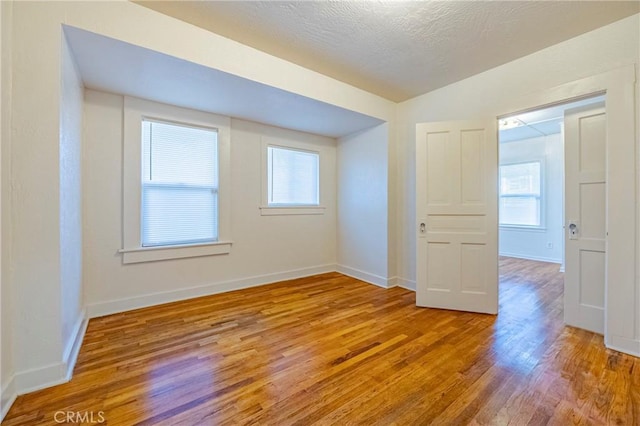 spare room featuring a textured ceiling and light wood-type flooring