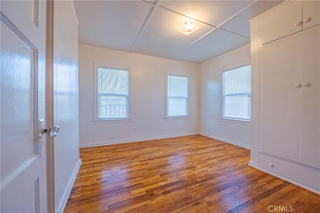 empty room featuring a healthy amount of sunlight and hardwood / wood-style floors