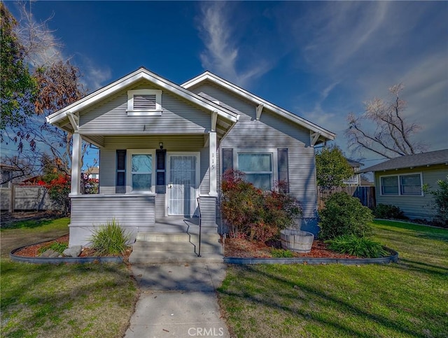 bungalow-style home with a front lawn and covered porch