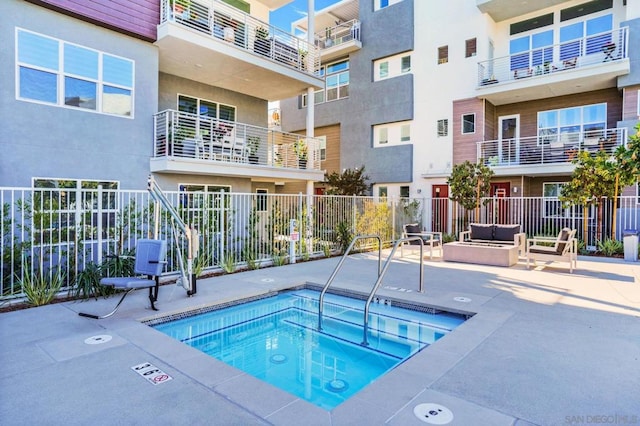 view of pool with a hot tub and a patio