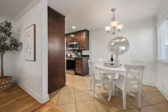 tiled dining room featuring ornamental molding and a chandelier