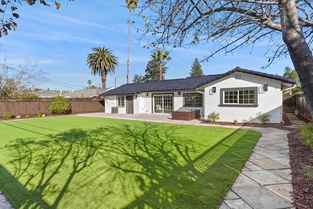 back of property featuring a lawn and a patio area