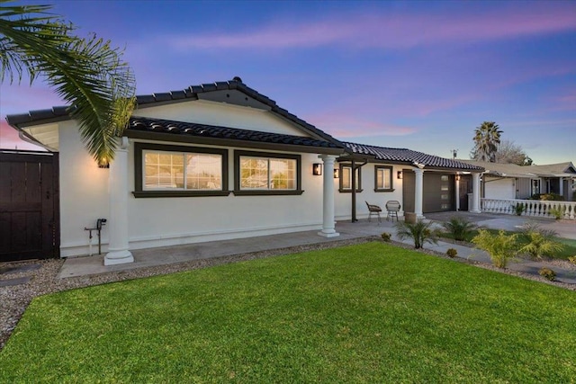 view of front of property with a garage and a lawn