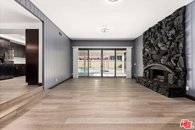 unfurnished living room featuring a fireplace and light hardwood / wood-style flooring