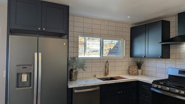 kitchen featuring appliances with stainless steel finishes, tasteful backsplash, sink, light stone counters, and wall chimney range hood