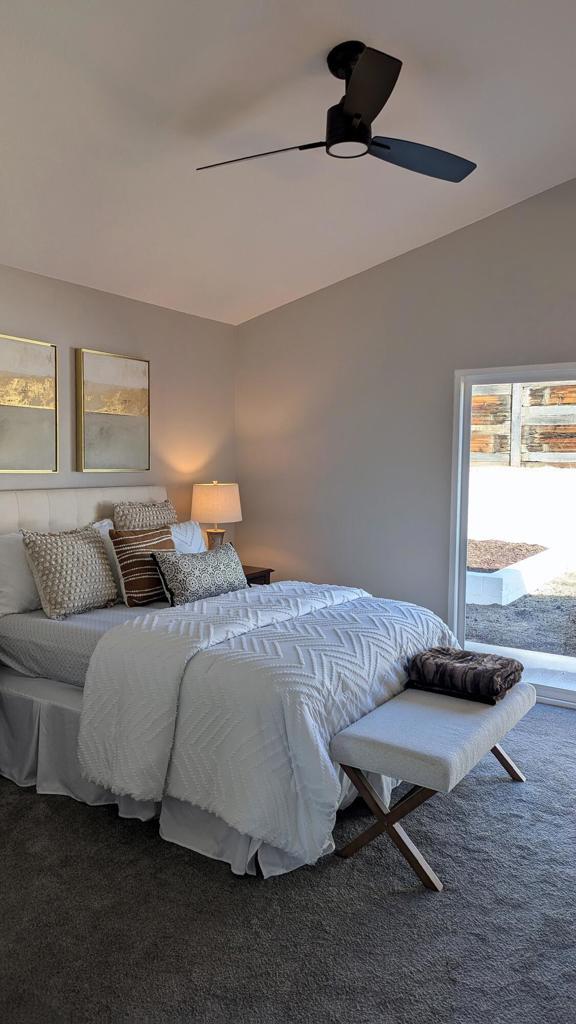 bedroom with ceiling fan, vaulted ceiling, and carpet