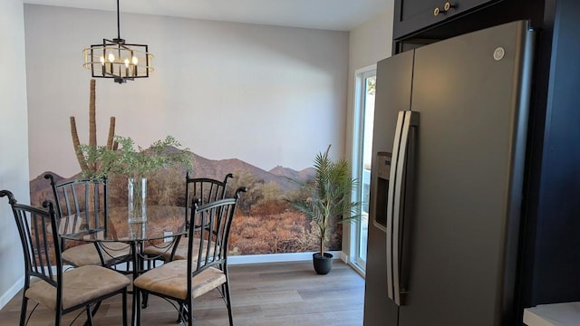 dining area with an inviting chandelier and light wood-type flooring