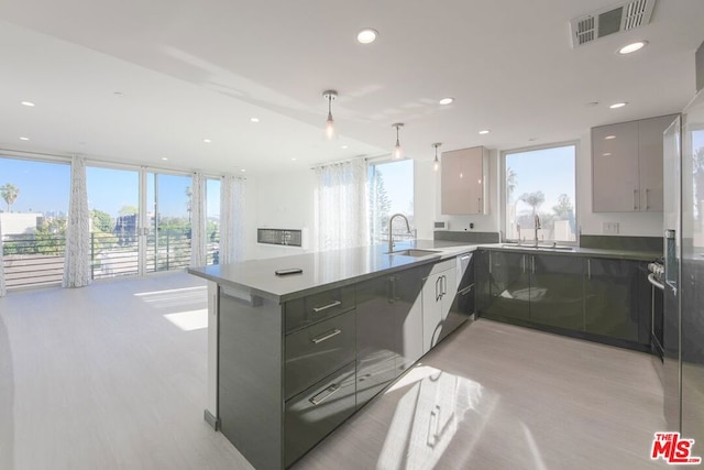 kitchen featuring gray cabinets, hanging light fixtures, sink, and kitchen peninsula