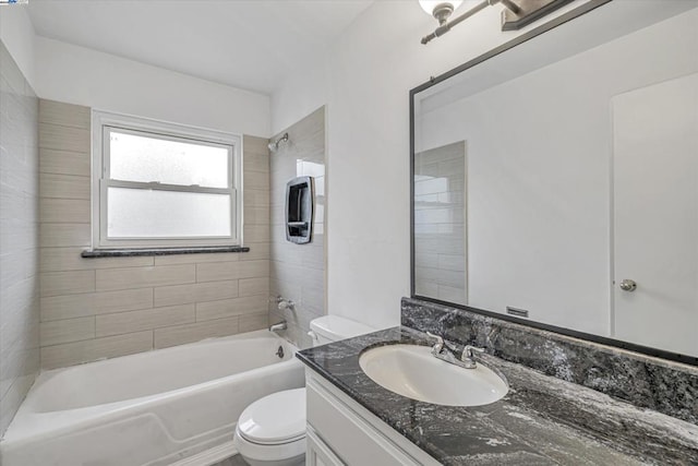 full bathroom featuring tiled shower / bath combo, vanity, and toilet