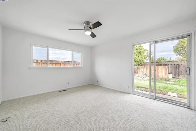 empty room featuring ceiling fan and carpet