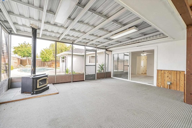 unfurnished sunroom with a wood stove