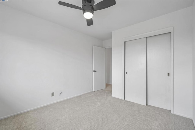 unfurnished bedroom with light carpet, a closet, and ceiling fan