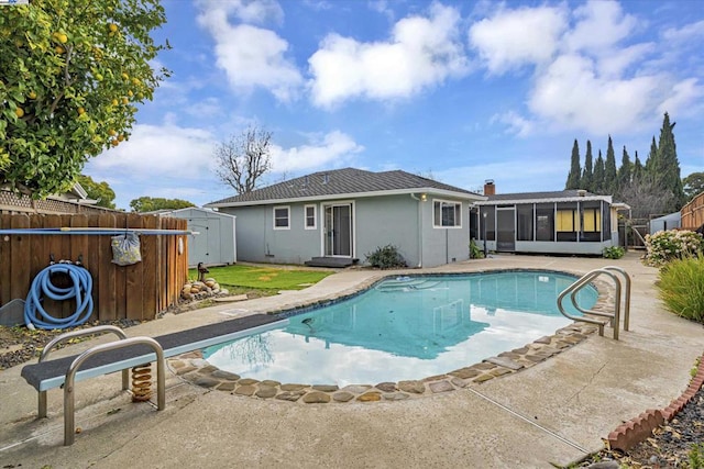 view of pool featuring a storage shed, a patio area, and a sunroom