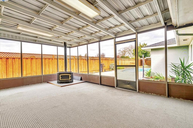 unfurnished sunroom featuring a wood stove