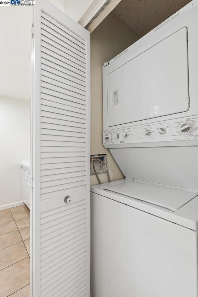 washroom featuring light tile patterned floors and stacked washer / dryer