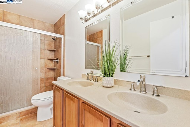 bathroom with vanity, toilet, and a shower with door