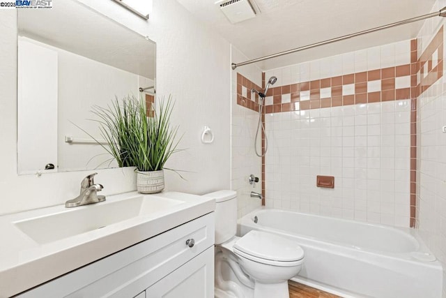 full bathroom featuring vanity, toilet, tiled shower / bath combo, and hardwood / wood-style floors