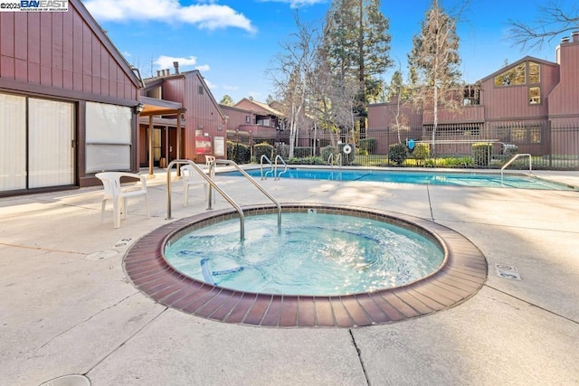 view of pool with a patio area and a community hot tub