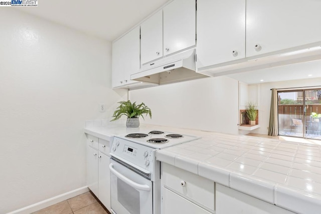 kitchen featuring white electric stove, white cabinetry, tile counters, and light tile patterned floors