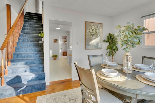 dining room featuring a textured ceiling and light wood-type flooring