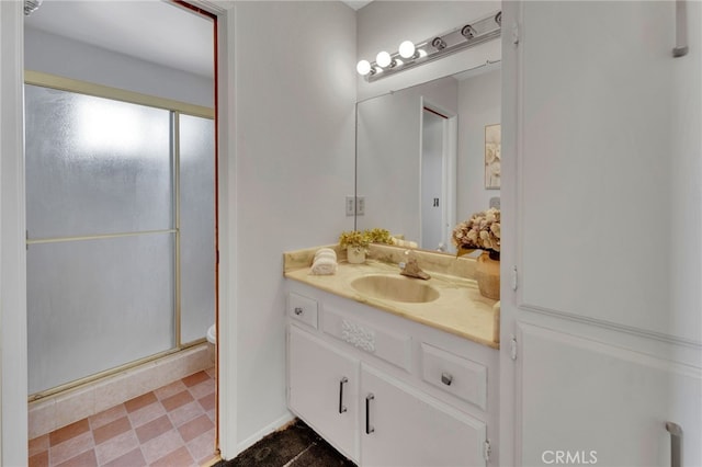 bathroom with vanity and a shower with door