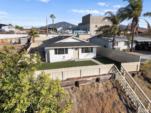 rear view of property featuring a mountain view and a yard