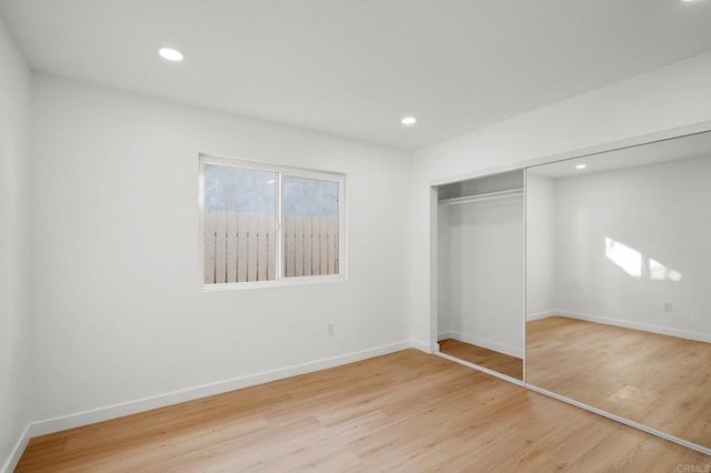 unfurnished bedroom with light hardwood / wood-style floors and a closet