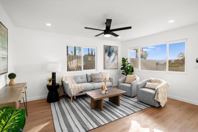 living room with ceiling fan, a healthy amount of sunlight, and light hardwood / wood-style floors