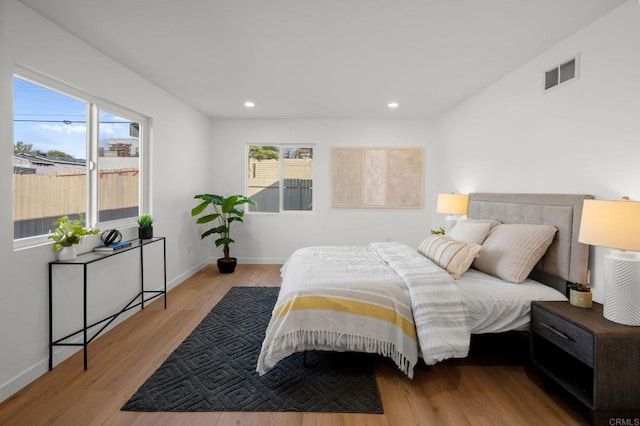 bedroom featuring multiple windows and light hardwood / wood-style floors