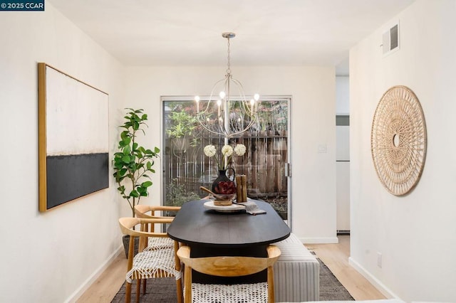 dining room with a chandelier and light hardwood / wood-style floors