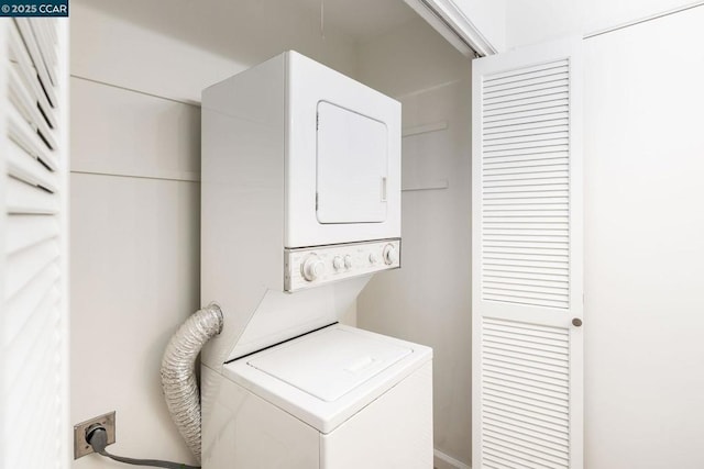 clothes washing area with stacked washing maching and dryer