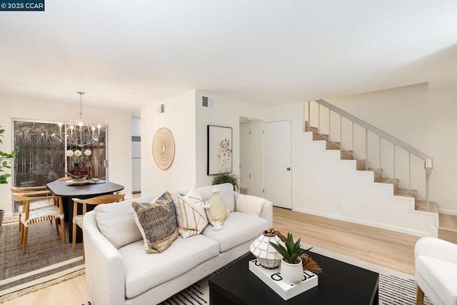 living room featuring an inviting chandelier and light hardwood / wood-style flooring