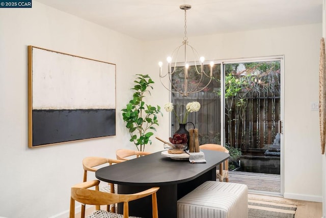 dining space with hardwood / wood-style flooring and a chandelier