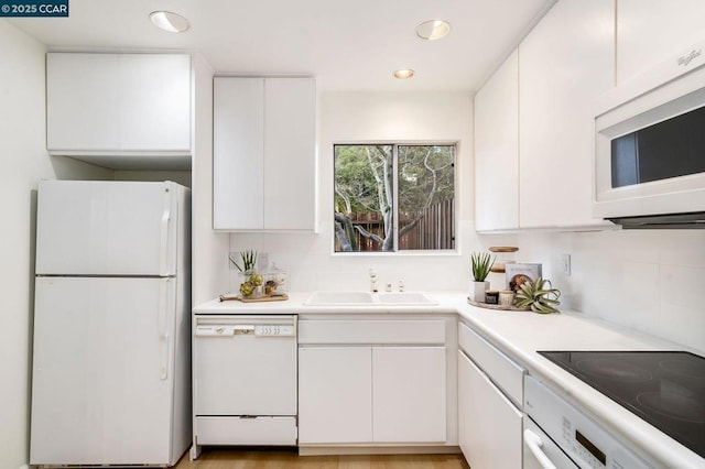 kitchen with white cabinetry, sink, and white appliances