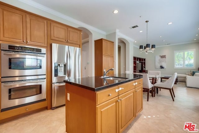 kitchen featuring sink, hanging light fixtures, ornamental molding, stainless steel appliances, and a kitchen island with sink