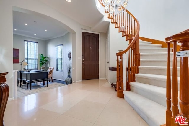 entryway with ornamental molding and light tile patterned floors