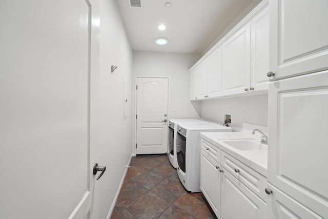 laundry room featuring cabinets, sink, and washing machine and clothes dryer