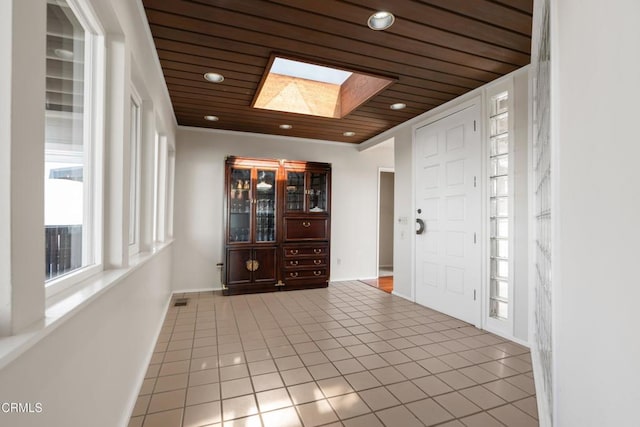 tiled foyer entrance featuring a skylight, recessed lighting, wood ceiling, and visible vents