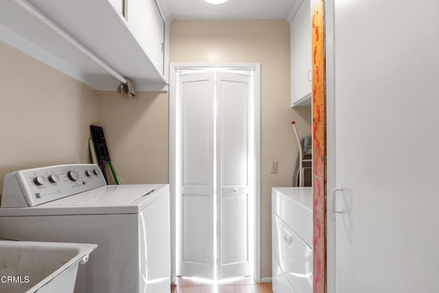 laundry room featuring cabinet space, light tile patterned floors, and independent washer and dryer