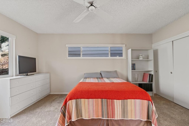 bedroom featuring a closet, carpet flooring, a textured ceiling, and ceiling fan